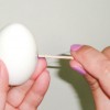 Ovos passo 3: Fure o ovo cozido DESCASCADO com o palito de dente amarrado, chegando até a metade da gema.