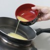 Omelete passo 3: Esquente uma frigideira e adicione uma colher (sopa) de óleo. Quando o óleo estiver quente, despeje os ovos batidos com muito cuidado.