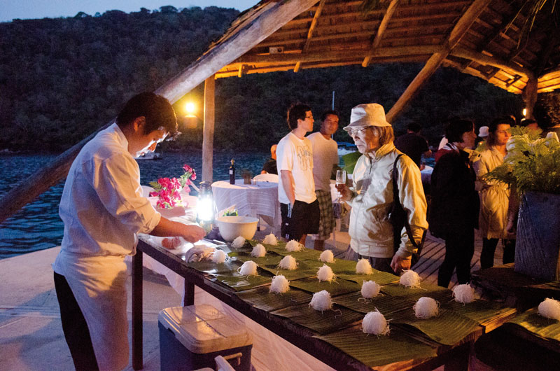Ponto alto do Eatrip: um jantar num flutuante, iluminado exclusivamente com lampião a gás e velas. O escultor Yutaka Toyota observa a destreza do chef Celso Amano, montando o balcão de sushi - fotos: Tatewaki Nio