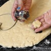 Passo 7: Quando estiver com uma espessura de aproximadamente 0,5 cm, use forminhas de biscoito para cortar a massa. Caso não tenha, use a boca de um copo.