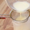 Passo 7: Peneire o líquido e distribua devagar nas forminhas carameladas para que a mistura não se incorpore à calda. Cubra cada fôrma com papel alumínio.