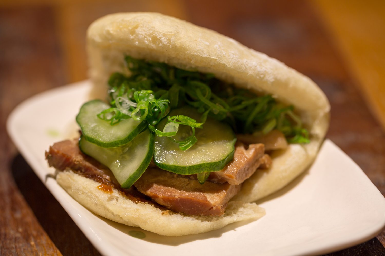 Bun: pão assado no vapor recheado com carne de porco e pepino. A opção vegetariana é recheada com shimeji.