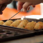 Takoyaki é uma das comidinhas de rua populares no Japão. O bolinho é cremoso e tem pedacinhos de polvo no recheio